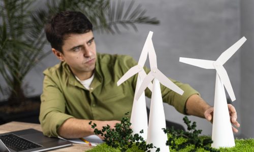 front-view-man-working-eco-friendly-wind-power-project-with-laptop-wind-turbines