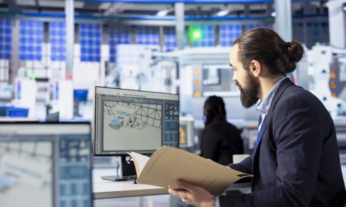 Inspector in solar panel factory checking up on manufacturing equipment, reading documentation files. Man in industrial facility inspecting green energy production process, checking paperwork